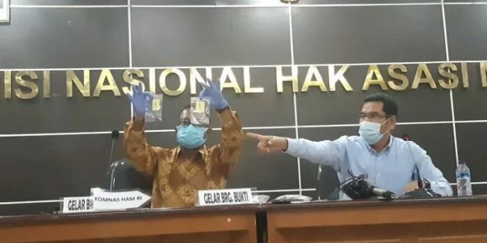 Komisioner Komnas HAM Choirul Anam menunjukan barang bukti.