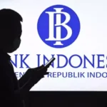 Seorang pria berjalan di dekat papan nama Bank Indonesia. (Antara Foto)