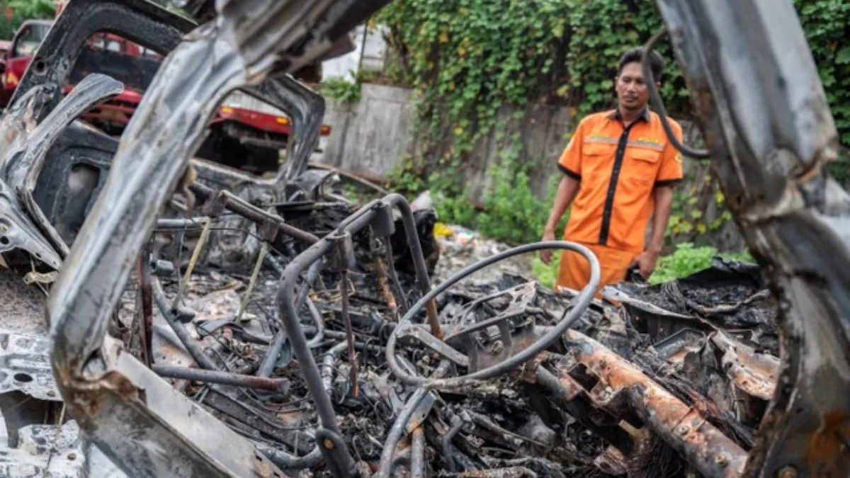 Seorang petugas melihat bangkai kendaraan pascakecelakaan di Tol Jakarta-Cikampek KM 58 di Pool Derek Cikopo,