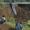 Warga mengamati kondisi jalan tol yang amblas di ruas tol Bocimi KM 64, Sukabumi, Jawa Barat, Kamis Henry Purb