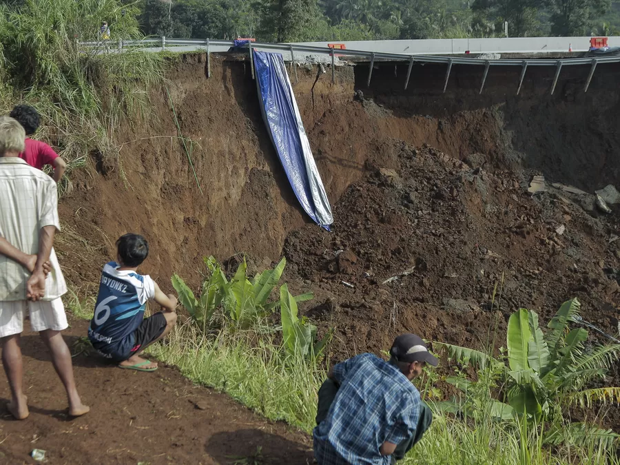 Warga mengamati kondisi jalan tol yang amblas di ruas tol Bocimi KM 64, Sukabumi, Jawa Barat, Kamis Henry Purb