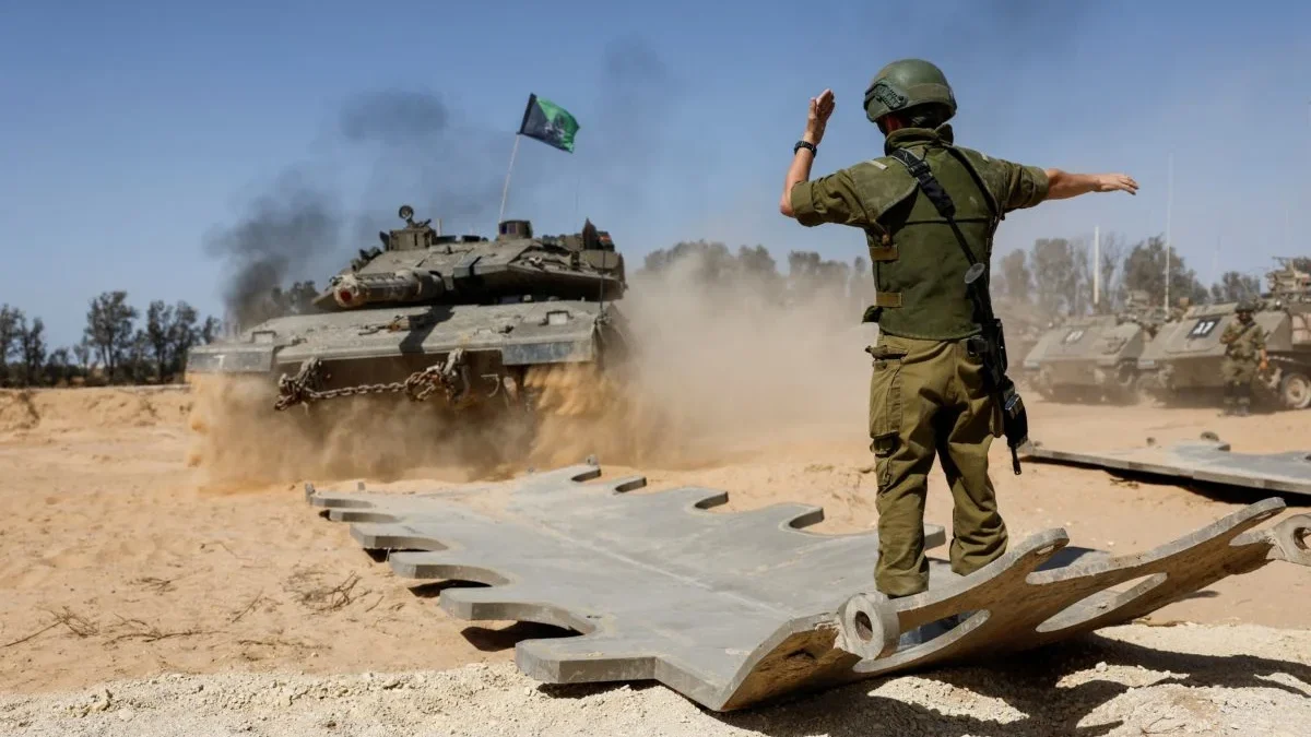 Seorang tentara Israel mengarahkan tank, dekat perbatasan Israel-Gaza, di tengah konflik yang sedang berlangsu