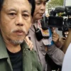 Epy Kusnandar tampak mengenakan jaket parka berwarna hijau