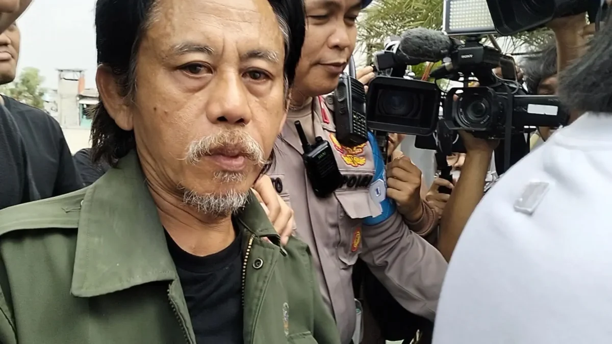 Epy Kusnandar tampak mengenakan jaket parka berwarna hijau