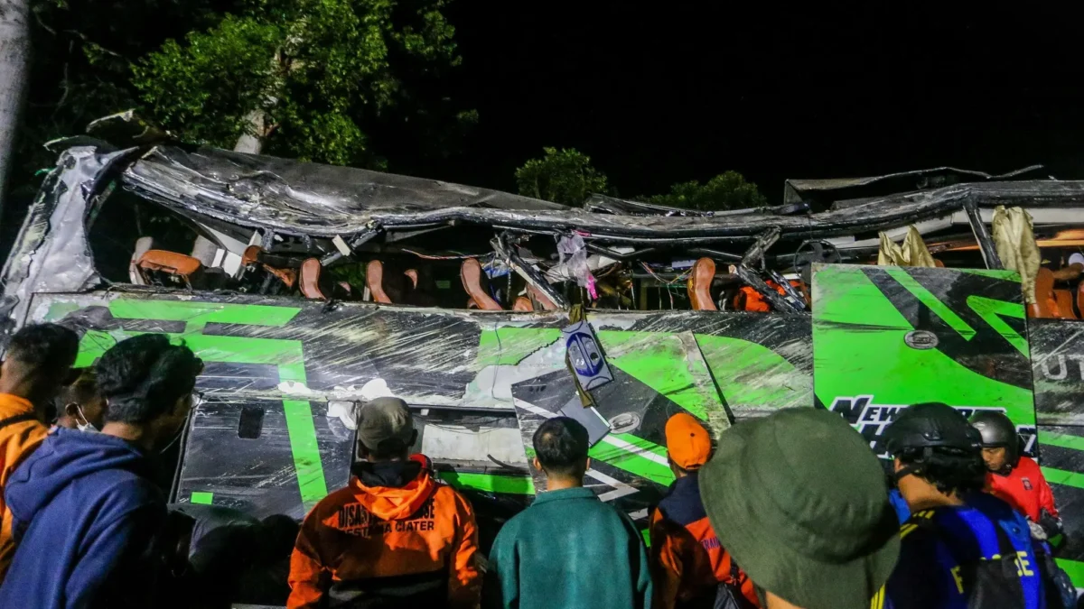 Petugas polisi dan penyelamat memeriksa puing-puing bus setelah kecelakaan pada hari Sabtu di Subang. (Ryan Su