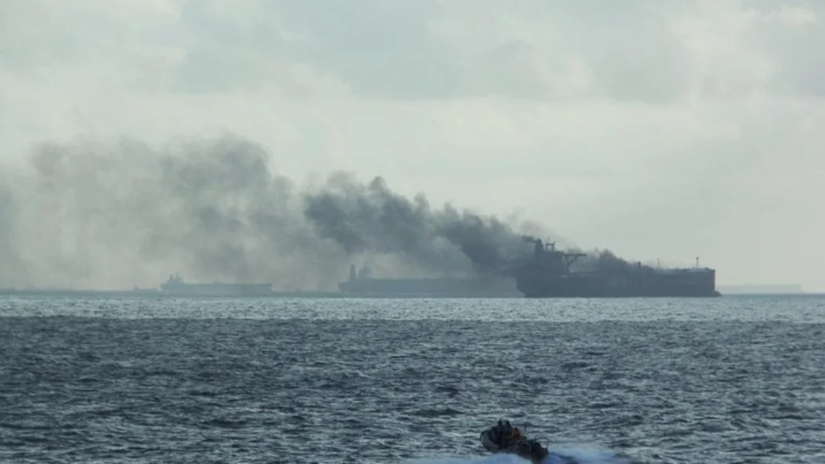 Perahu karet RSS Supreme dengan lambung kaku di sekitar kapal yang terbakar menyusul kebakaran di dua kapal ta