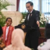 Presiden Joko Widodo alias Jokowi berbincang dengan Yohanes Ande Kala alias Joni, bocah pemanjat tiang bendera