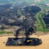 Foto udara alat berat memuat batu bara di tempat penampungan batu bara, tepi Sungai Batanghari, Muaro Jambi, J