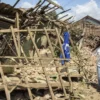 Warga melintas di dekat rumah yang rusak pascagempa bumi di Desa Cibeureum, Kertasari, Kabupaten Bandung, Jawa