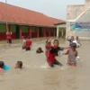 Siswa SDN 1 Bayalangu Kidul asyik main air saat banjir merendam sekolah mereka, Kamis, 16 Januari 2025.