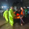 Petugas mengevakuasi warga yang masih terjebak banjir di Desa Sutawinangun Kedawung Cirebon. (ist