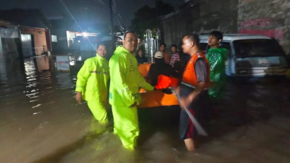 Petugas mengevakuasi warga yang masih terjebak banjir di Desa Sutawinangun Kedawung Cirebon. (ist