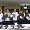 Polisi menunjukkan tersangka dan barang bukti komplotan love scamming di Apartemen Batavia saat konferensi per