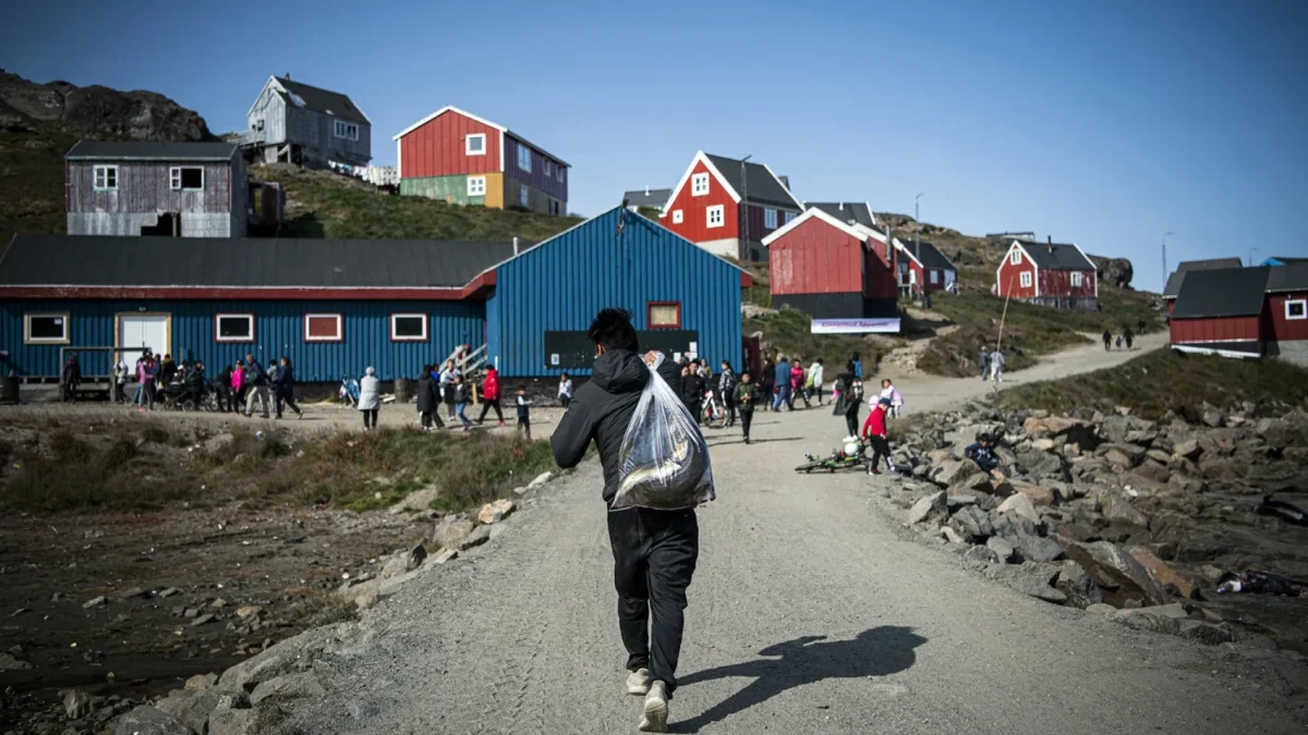 Seorang pria membawa ikan dari perjalanan memancing di Kulusuk, Greenland. (Foto: Jonathan Nackstrand/AFP/Gett