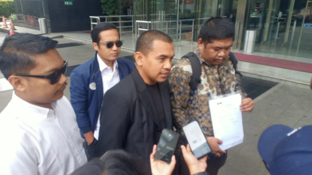 Pelapor, Muhammad Fithrat Irfan (kanan) bersama kuasa hukumnya, Azis Yanuar (tengah) di Gedung Merah Putih KPK