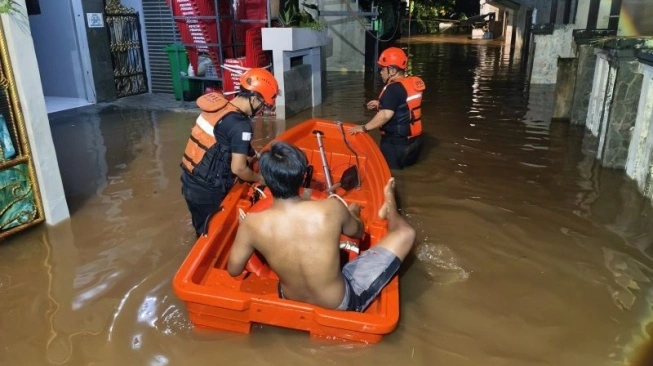 Petugas BPBD Jakarta Selatan mengevakuasi warga terdampak banjir di Masjid Al Makmur, Pejaten Timur, Pasar Min