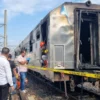 Gerbong kereta api yang terbakar di Stasiun Tugu Yogyakarta dipasangi garis polisi, Rabu (12/3/2025). - Istime