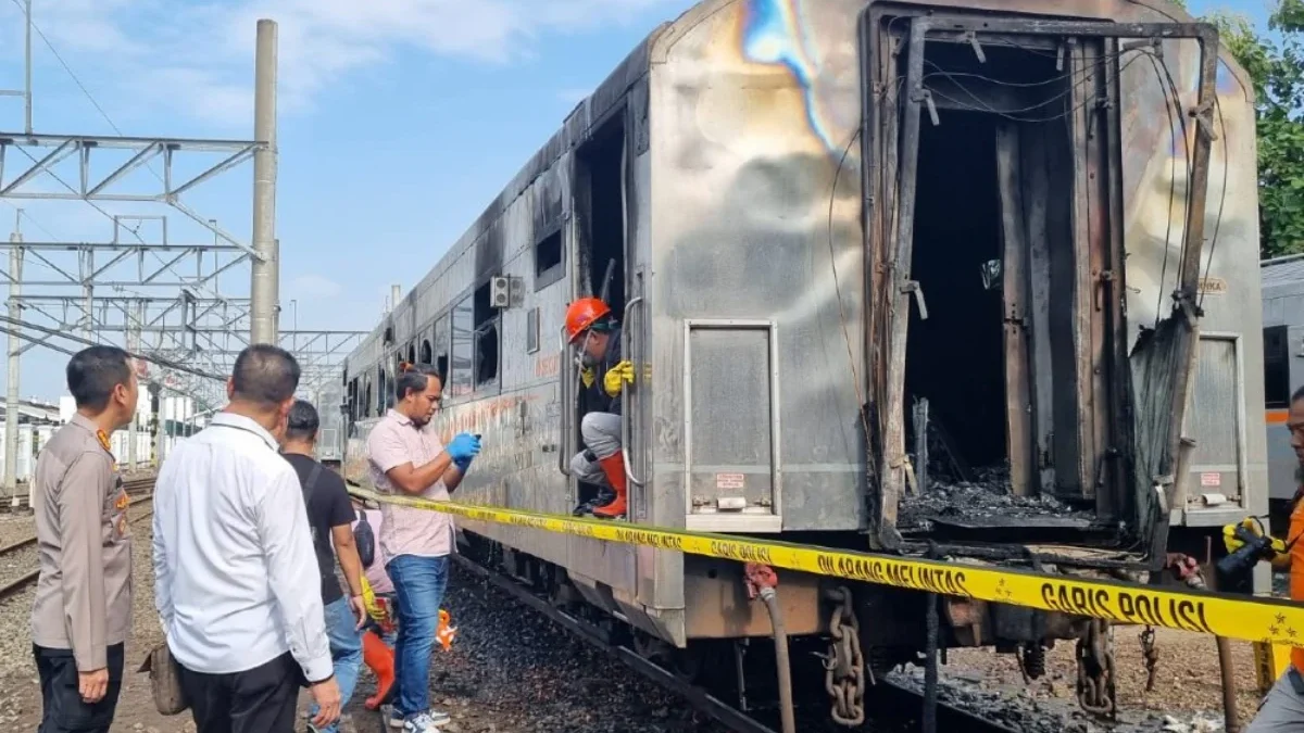 Gerbong kereta api yang terbakar di Stasiun Tugu Yogyakarta dipasangi garis polisi, Rabu (12/3/2025). - Istime