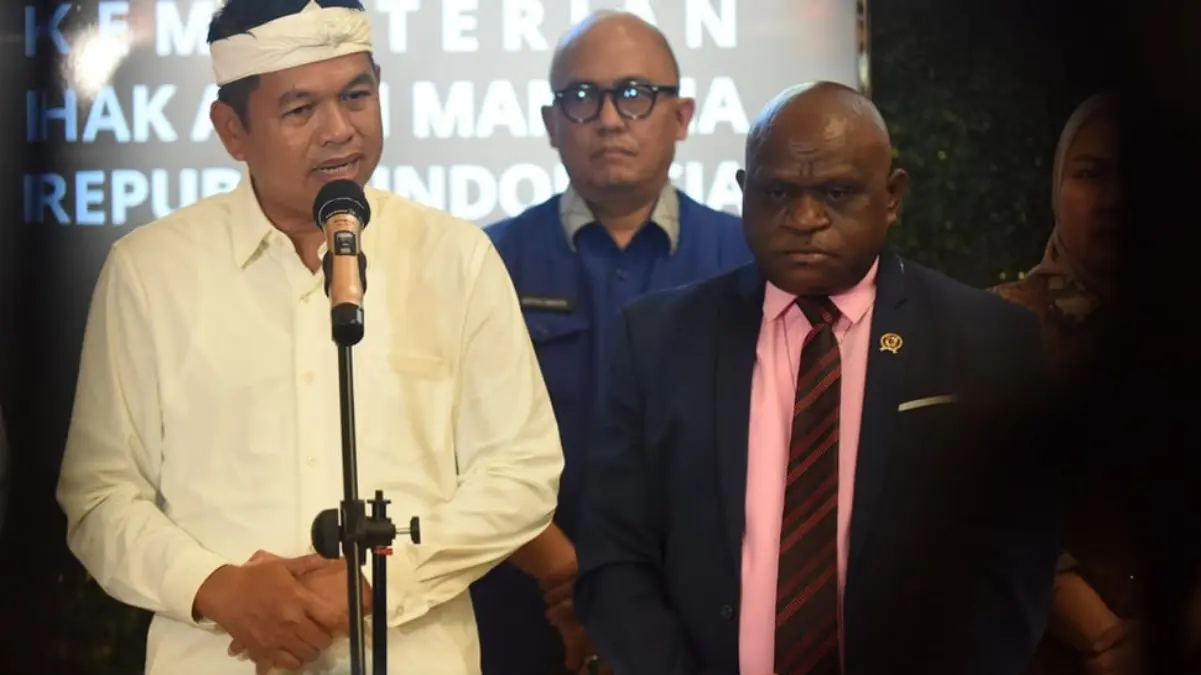 Menteri Hak Asasi Manusia (HAM) Natalius Pigai (kanan) bersama Gubernur Jawa Barat Dedi Mulyadi (kiri) memberi