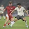 Pesepak bola Timnas Indonesia Ole Lennard Romenij (kiri) berebut bola dengan pesepak bola Timnas China Zhu Che