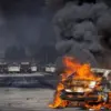 Sebuah mobil terbakar di Atlantic Boulevard saat terjadi kebuntuan antara pengunjuk rasa dan penegak hukum, me