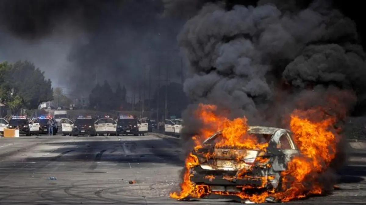 Sebuah mobil terbakar di Atlantic Boulevard saat terjadi kebuntuan antara pengunjuk rasa dan penegak hukum, me