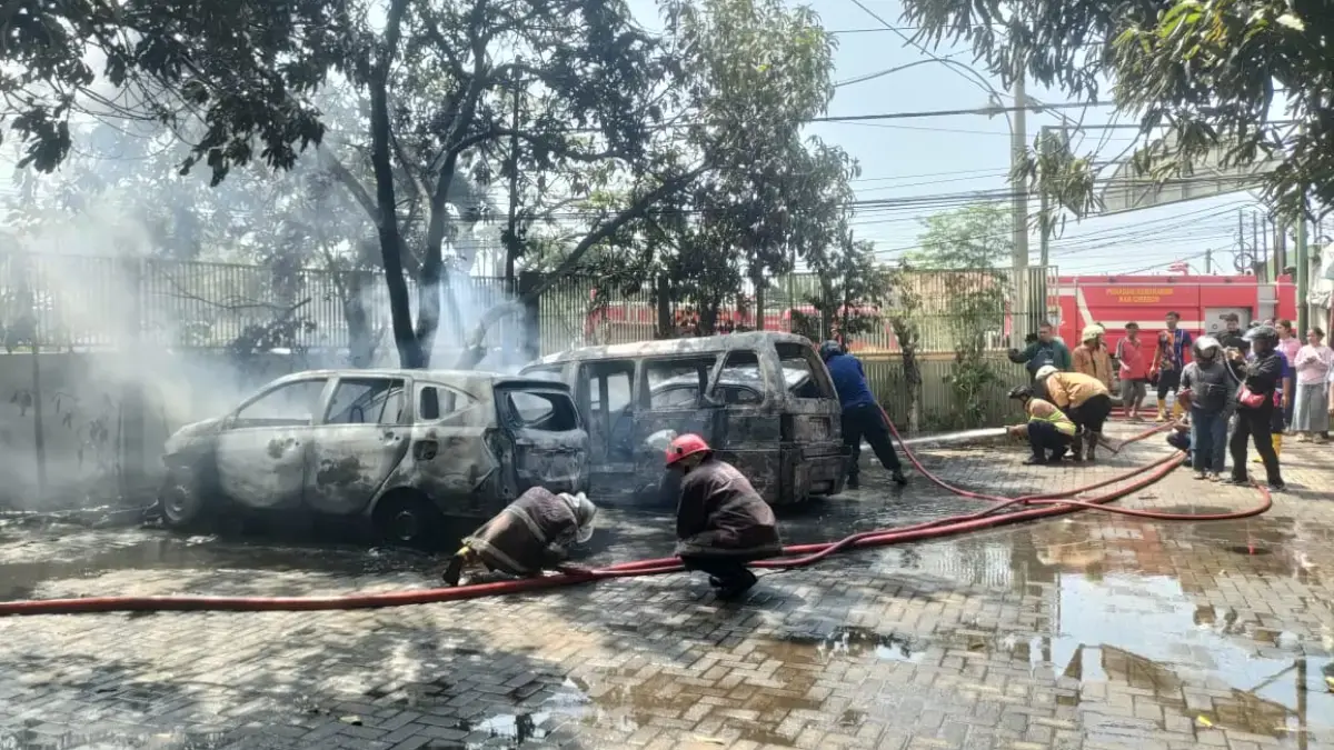 Petugas Damkar nampak melakukan pendinginan tiga unit mobil yang terbakar di halaman sebuah mesjid di Cirebon