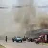Asap mengepul dari atap sebuah toko swalayan yang terhubung dengan sebuah SPBU di Provinsi Sisaket setelah ter