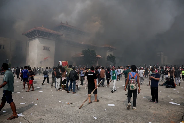 Demonstran berkumpul saat asap mengepul di kompleks Parlemen, Kathmandu, Nepal, Selasa (9/9/2025). Foto: Adnan