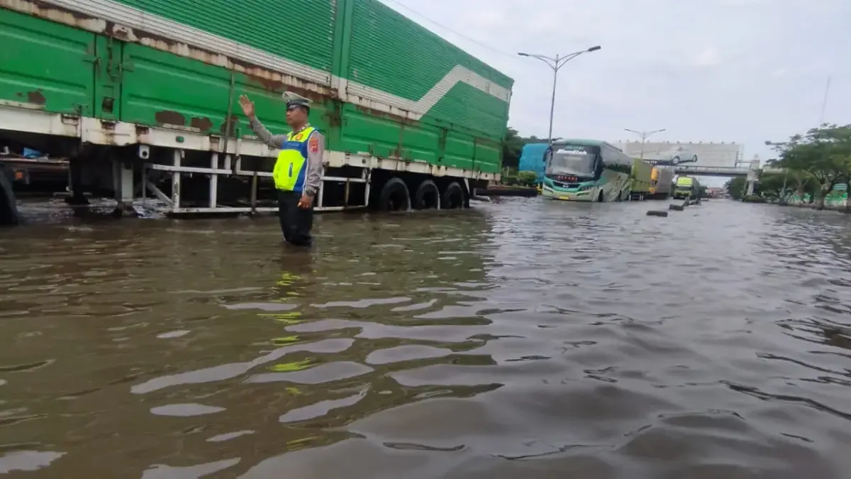 BMKG: Masyarakat Pesisir Waspadai Potensi Banjir Rob, Berikut Sejumlah Wilayah Terdampak Pasang Air Laut Petugas tengah mengatur kendaraan di ruas jalan yang masih tergenang air. (Ist)