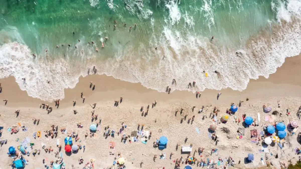 Orang-orang menuju ke pantai di San Diego pada hari musim panas yang panas (Kevin Carter/Getty Images)