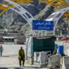 Seorang pria berjalan melintasi halte bus di kota perbatasan Pakistan-Afghanistan Torkham pada 13 Oktober 2025