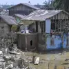 Warga berada di atas rumahnya yang rusak akibat banjir di Kuala Simpang, Aceh Tamiang, Aceh, Kamis (11/12/2025