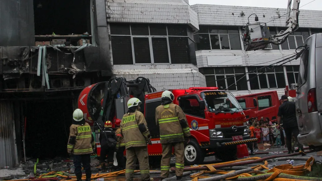 Api Muncul Pertama Kali di Bagian Atas Lantai Dasar, Karyawan Sempat Padamkan Baterai Drone yang Terbakar Petugas pemadam kebakaran mengeluarkan asap saat melakukan pencarian korban kebakaran di perkantoran Terra Dro