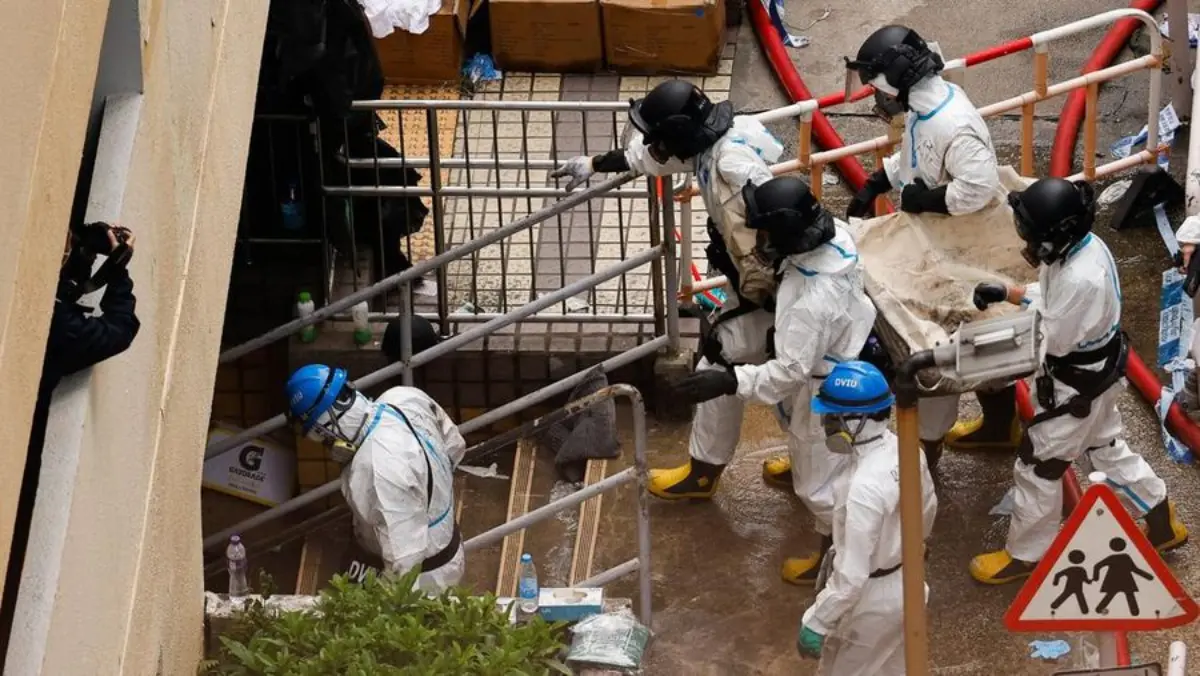 Petugas dari Unit Identifikasi Korban Bencana Hong Kong terlihat mengevakuasi jenazah pada Senin (1/12/2025),